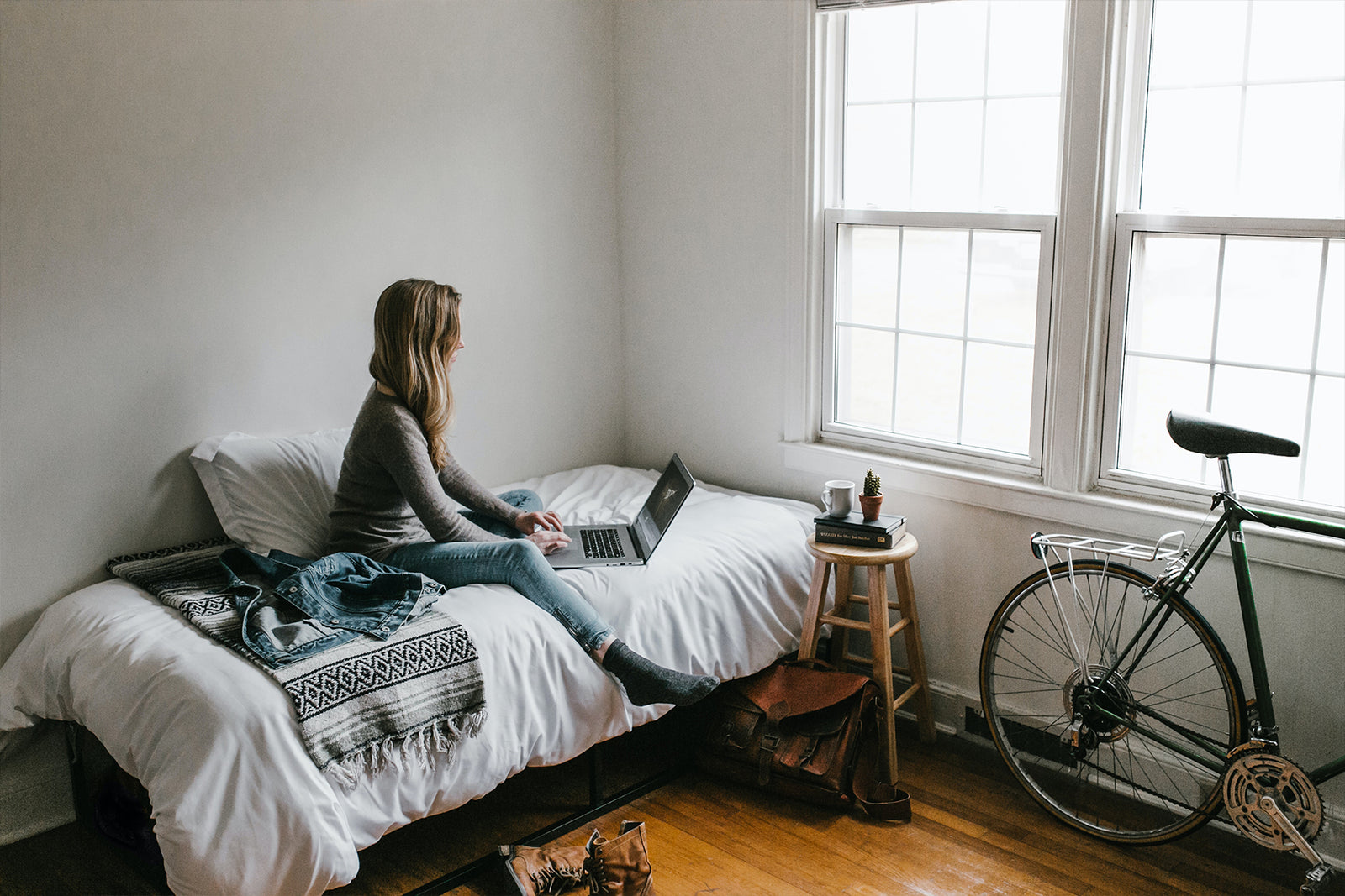 person sitting on bed working