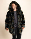 Man laughing and looking to the side, wearing a multicolor camo fake fur jacket with a hood on a beige background