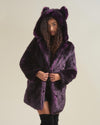 Curly, dark haired girl with hood and ears up, holding midnight wolf fake fur jacket closed in front of her body.