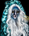 A Woman wearing SpiritHoods Classic Aqua Cat Blue Fake Fur Jacket with leopard print throughout, with blue leopard face paint and cat whiskers. halloween make up. Animal-themed costume ideas. Halloween Outfits.