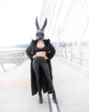 A Woman wearing a large oversized rabbit mask, and SpiritHoods Long Black Panther Fake Fur Jacket, looking at the camera. Easy Halloween Costume Ideas. Halloween Outfits.