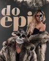 A woman with a half skull painted on her face wearing SpiritHoods Grey Wolf Hooded Faux Fur Coat looking at the camera as a man with a full skull face is squating down in the Grey Wolf Hooded Fake Fur Jacket looking at the camera. Easy Halloween Make Up Ideas. Halloween Costumes.
