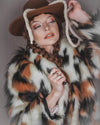 Woman wearing SpiritHoods Manx Cat Fake Fur coat and a hat with braided hair and a lasso hanging from the hat, against a gray background. Easy Cowgirl halloween costume ideas. Halloween Outfit for Women