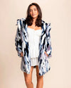Women wearing SpiritHoods Hooded Fake Fur Coat in Blue Lucky Rabbit, with her hands in the two outer pockets, smiling at the camera. Top Rated Vegan Fashion Brand.