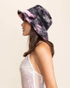 Woman wearing a tie-dye bucket hat on a beige background