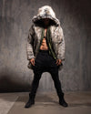 Man wearing a Hooded Men's Faux Fur Coat in Grey Wolf with the hood up as he looks down, against a textured gray background