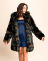 Woman wearing a green and brown faux fur coat over a blue dress on a beige background. Fall fashion meets festival fashion in the Women' s Camo Cat Fake Fur CCoat