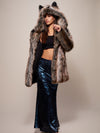 Woman wearing Grey Wolf Classic Faux Fur Coat in long floor length indigo sequin skirt