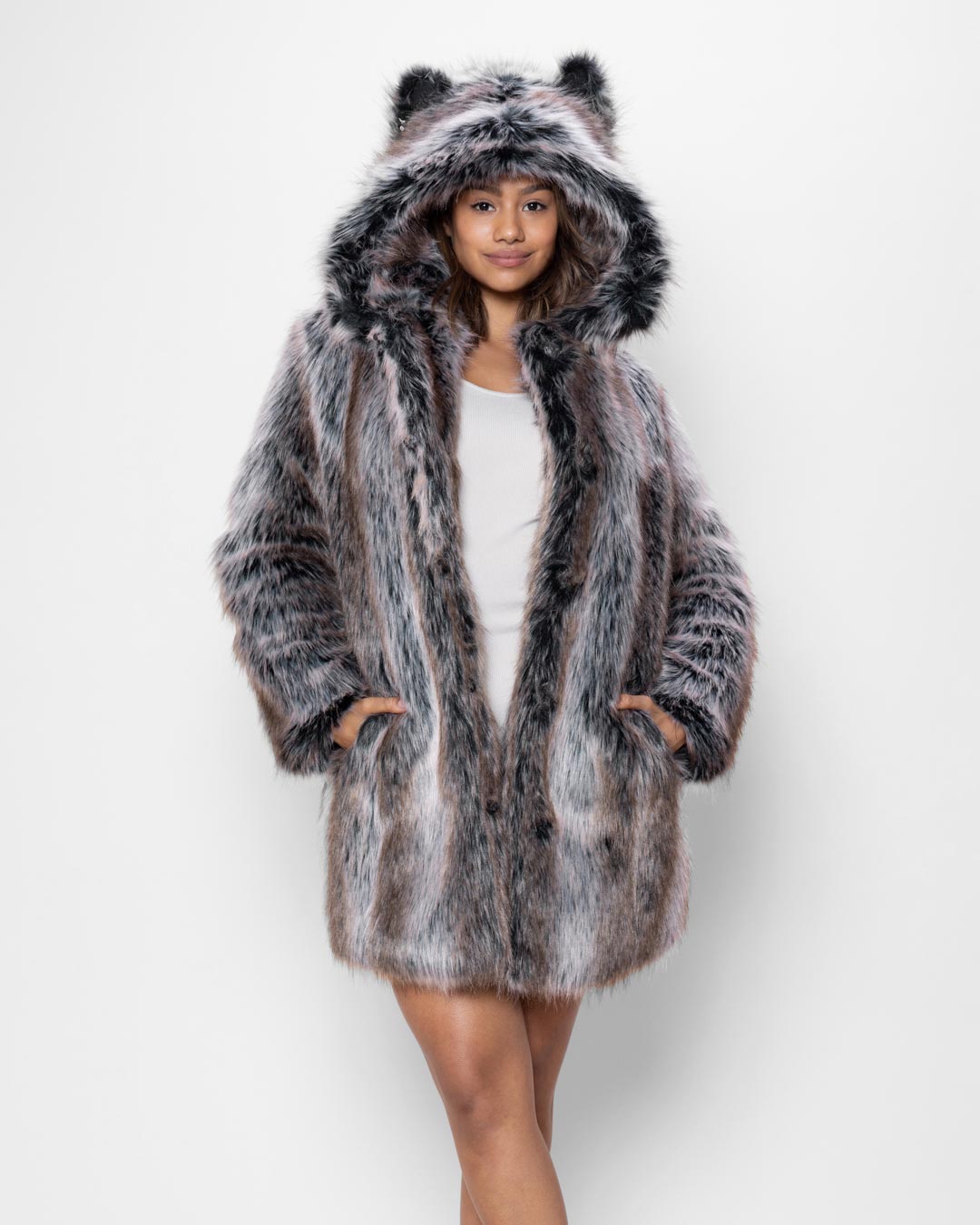 Female model standing in front of a white background wearing a white shirt and a grey faux fur coat with a hood and animal ears.