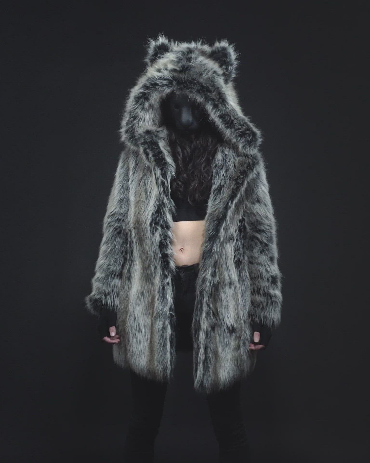 A video of a woman wearing black jeans, a black crop tank top and a hooded faux fur coat by SpiritHoods.