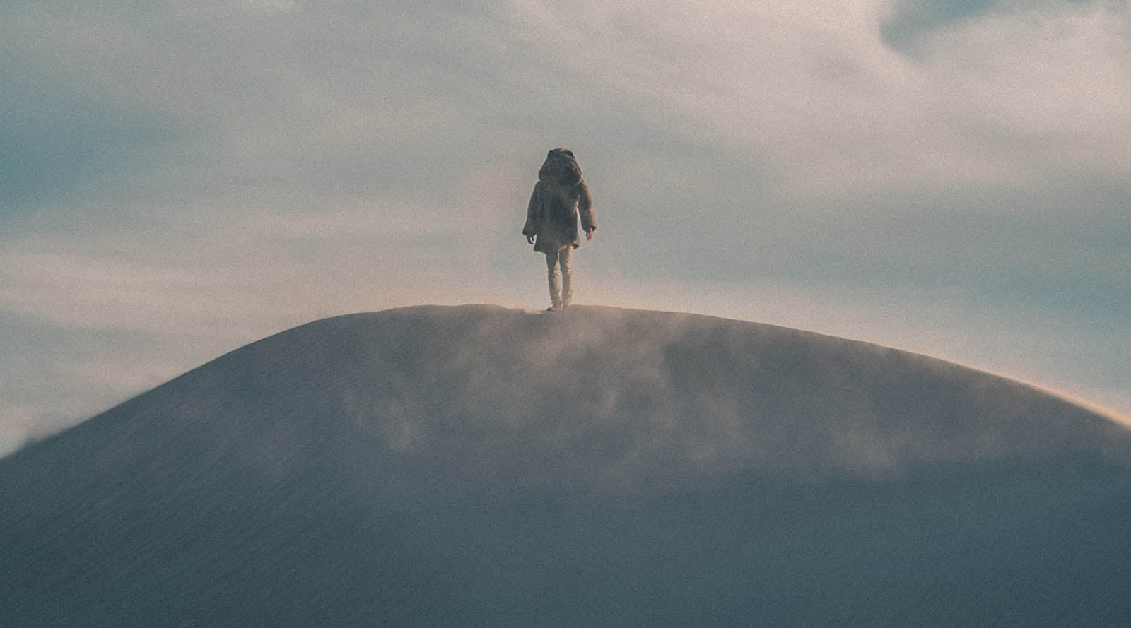 person wearing faux fur standing on top of mountain