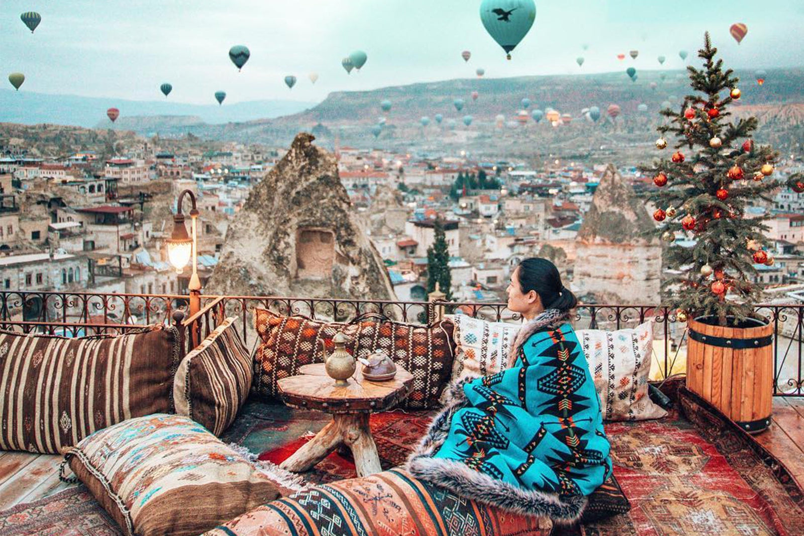 person sitting down while wrapped in faux fur throw at hot air balloon event