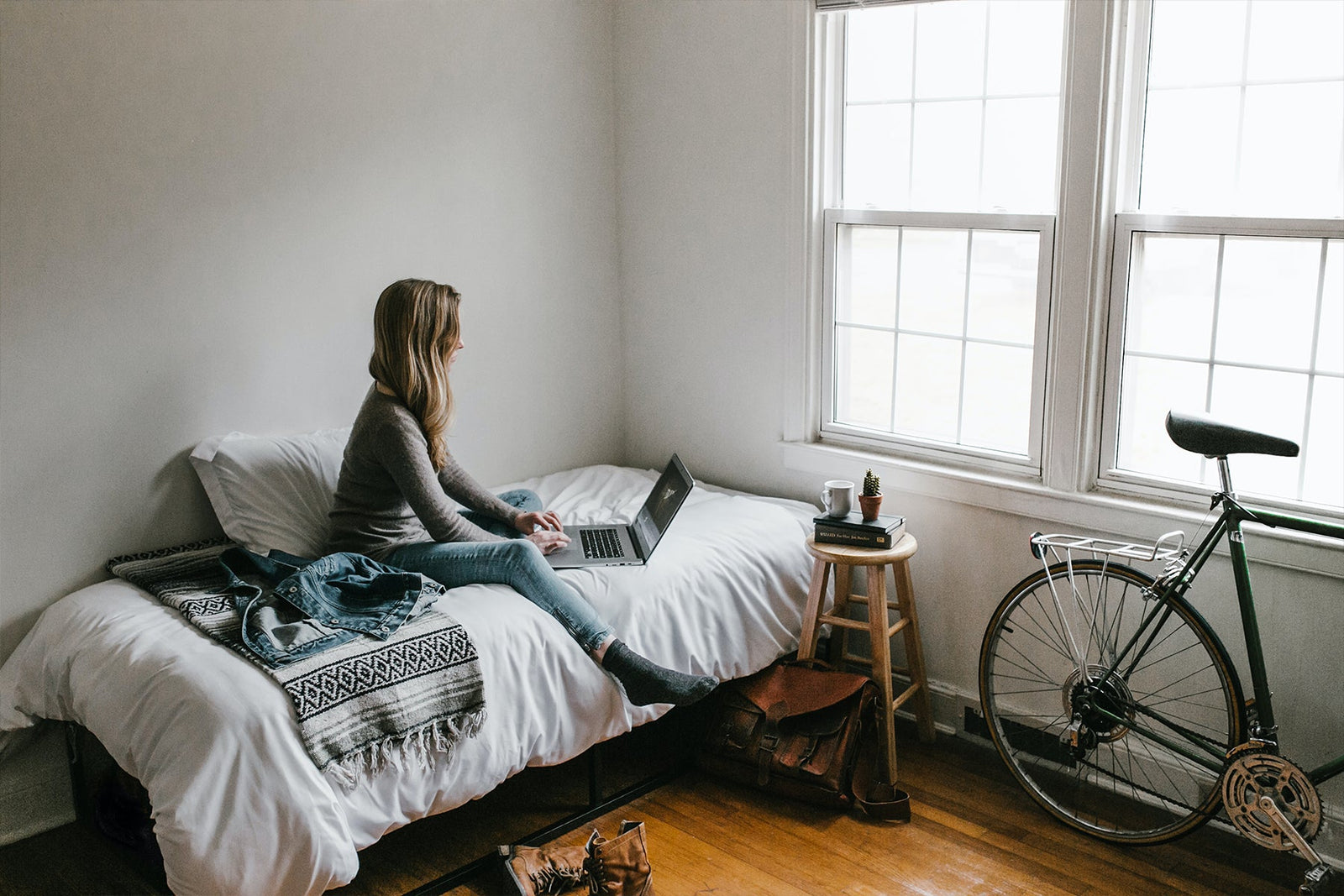 person sitting on bed working
