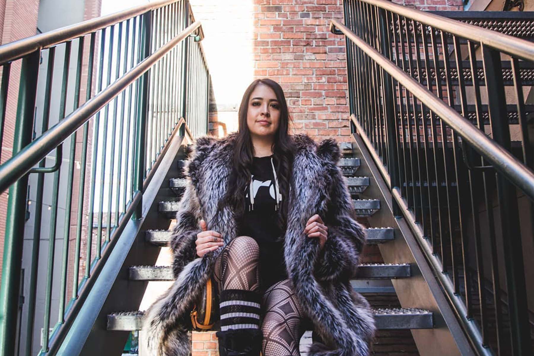 person wearing faux fur sitting on stairs