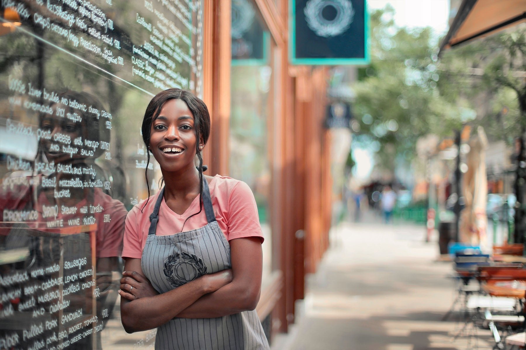 black woman standing next to window outside of store