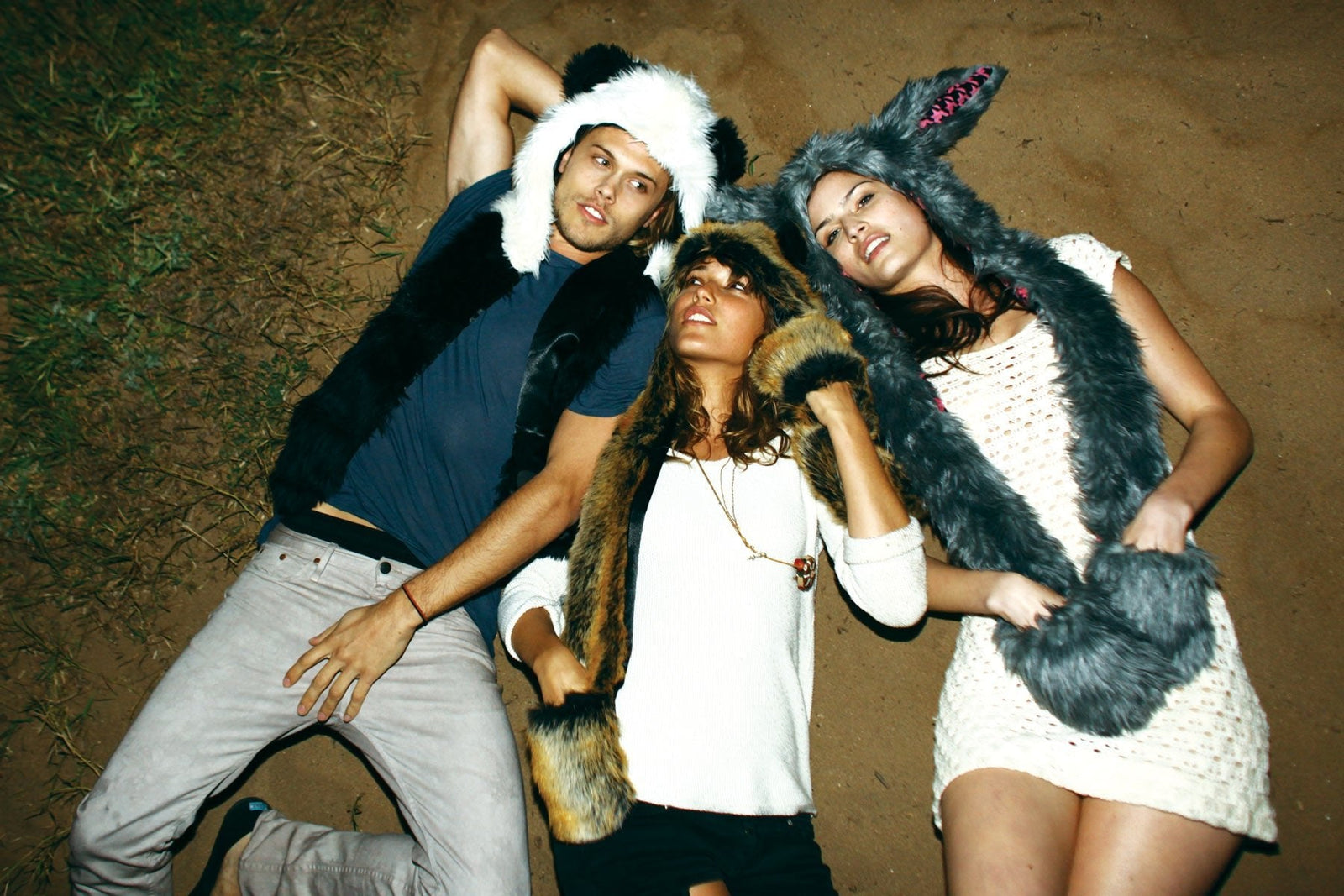 people lying on the beach wearing faux fur hoods