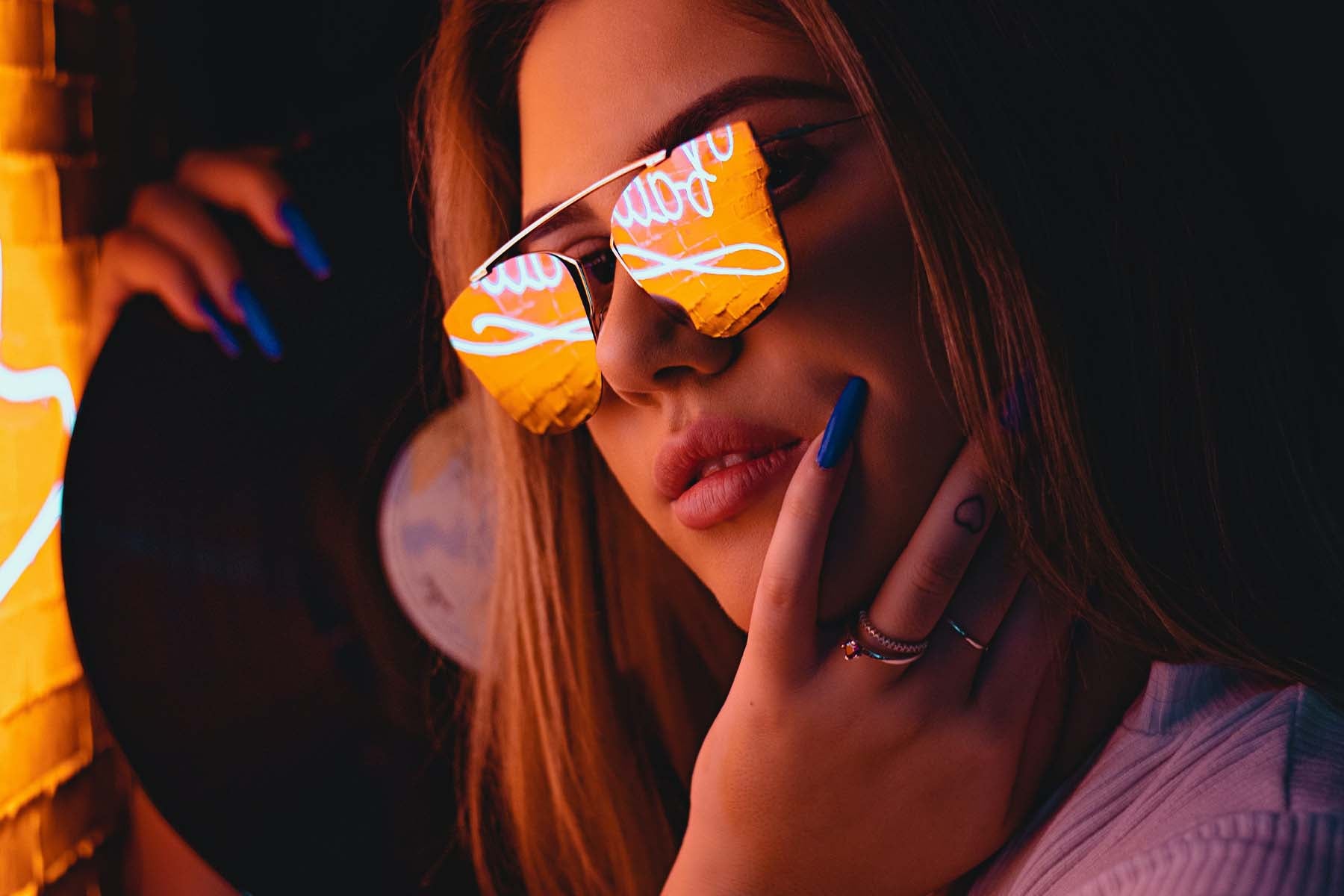 woman holding record player and wearing sunglasses