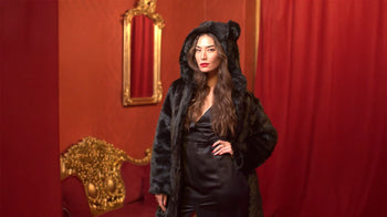 A woman wears the classic black panther faux fur coat by SpiritHoods.