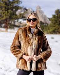 An image of a woman wearing a brown faux fur coat by Fabulous Furs.