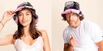A woman and a man wear the cotton candy faux fur bucket hat by SpiritHoods.