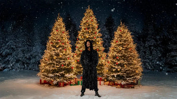 A man wears the black sequin long coat by SpiritHoods.