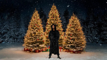 A man wears the black sequin long coat by SpiritHoods.