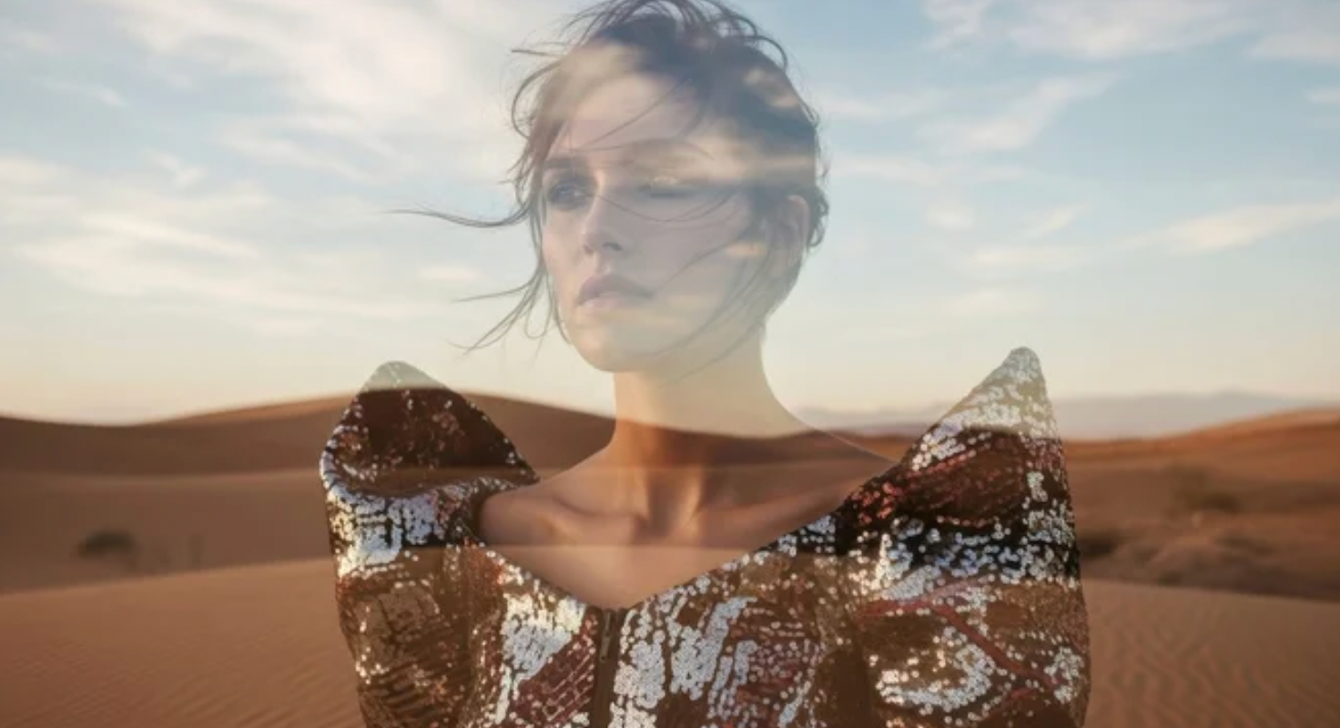 An image of a woman wearing sequins standing in the desert.