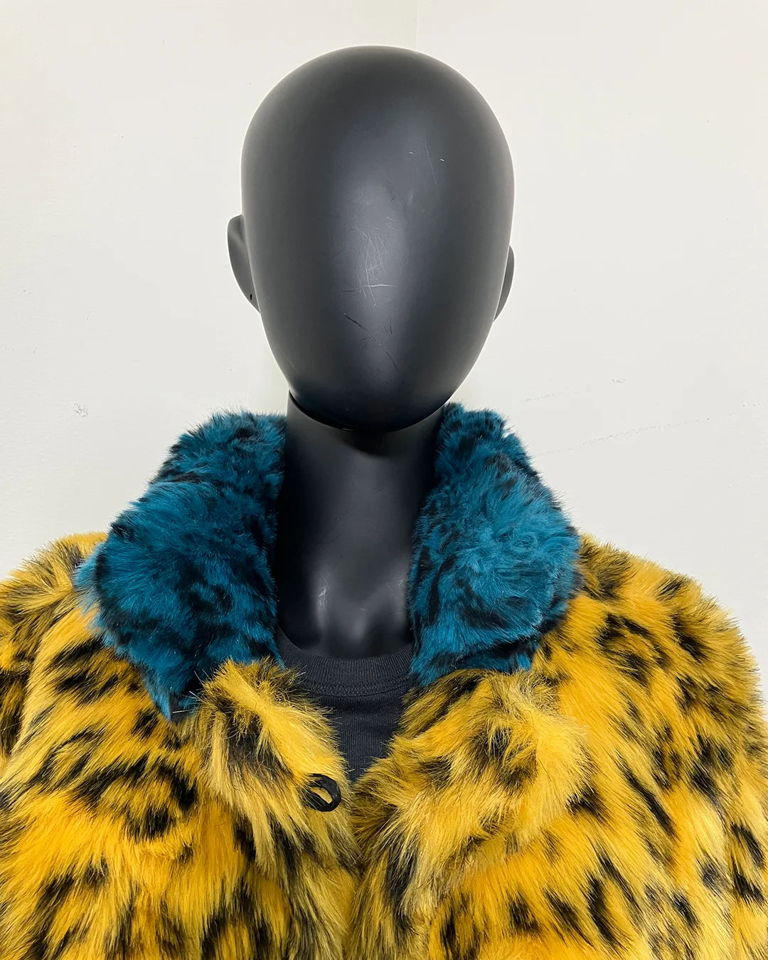 close-up photo of a mannequin wearing SpiritHoods Online Sample Sale Style: Calf Length Faux Fur Coat in Yellow Cheetah size: MEDIUM. show caseing the shorter pile blue cheetah print fake fur collar.