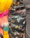 Close-up of a colorful fabric with butterfly pattern and fluffy multicolor accents. Also showing the inner secret zipper pocket on the butterfly calf length faux fur coat