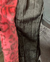 Close-up of a mannequin wearing a neon pink textured coat with black lining 