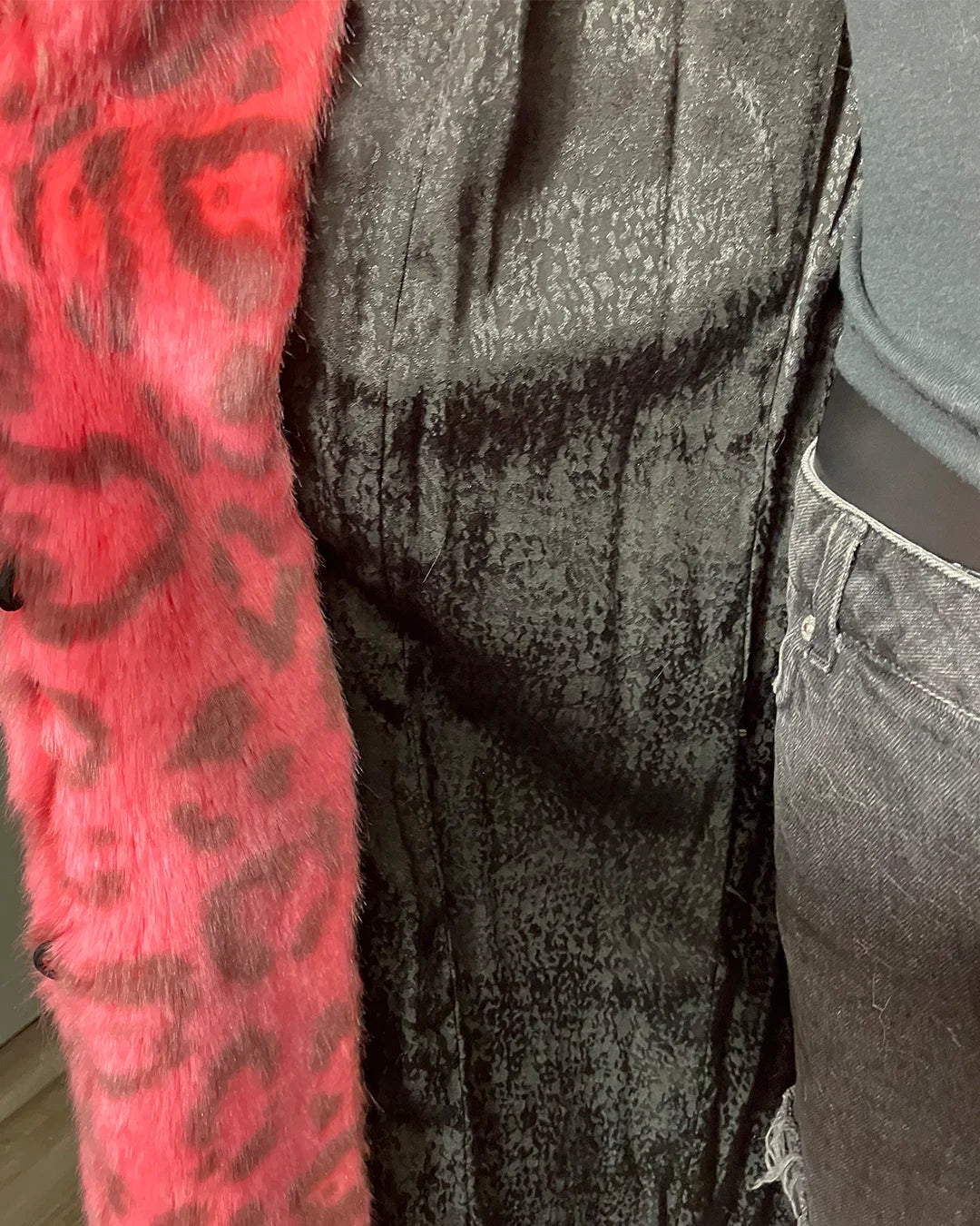 Close-up of a mannequin wearing a neon pink textured coat with black lining 