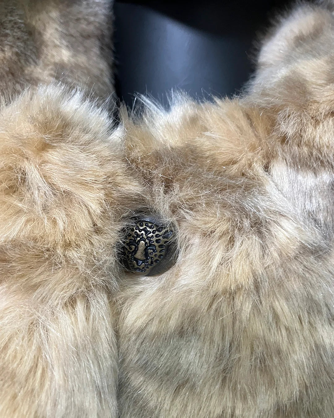 Close-up of the African Golden Cat Online Sample Sale Coat with a button in the center showing the Leopard Face button closure.