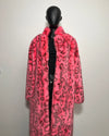 Mannequin wearing a pink fake fur coat with black leopard print pattern on a white background