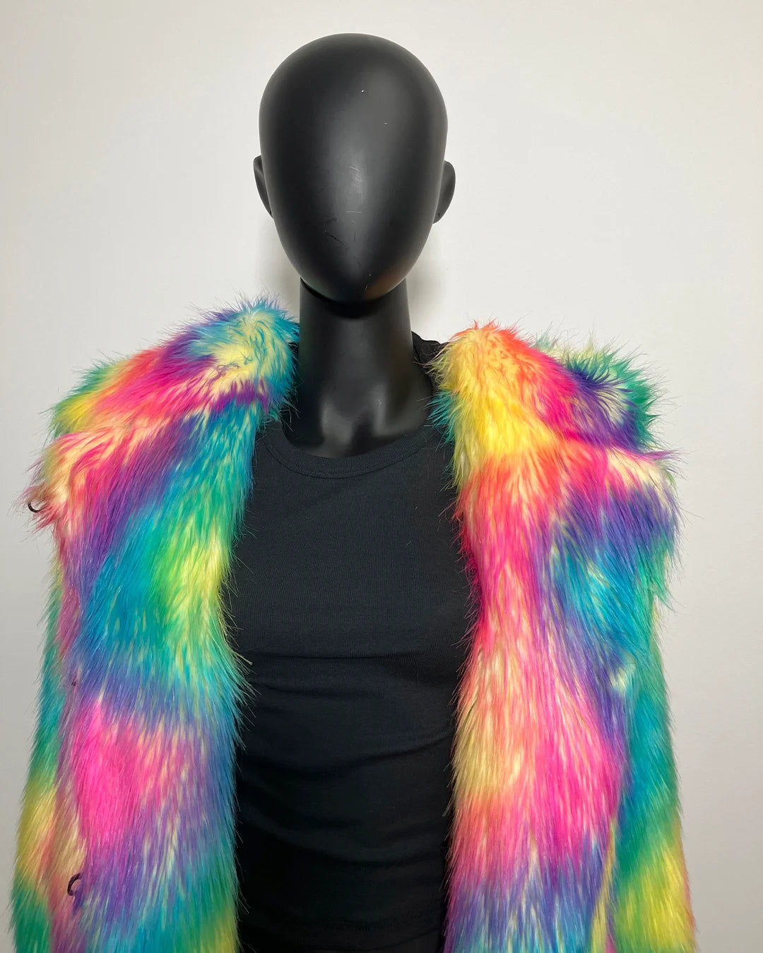 Mannequin wearing a colorful fur vest against a plain background
