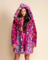 Woman wearing a colorful animal print faux fur coat with a large oversized hood on a beige background. SpiritHoods Made to Order Fall Winter Faux Fur Coat Collection and Fake Fur Animal Print Jackets