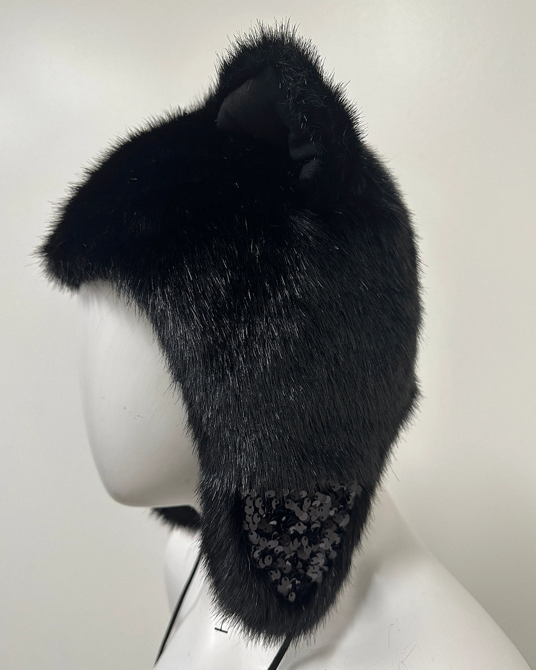 Side angle of black fur hat with decorative elements