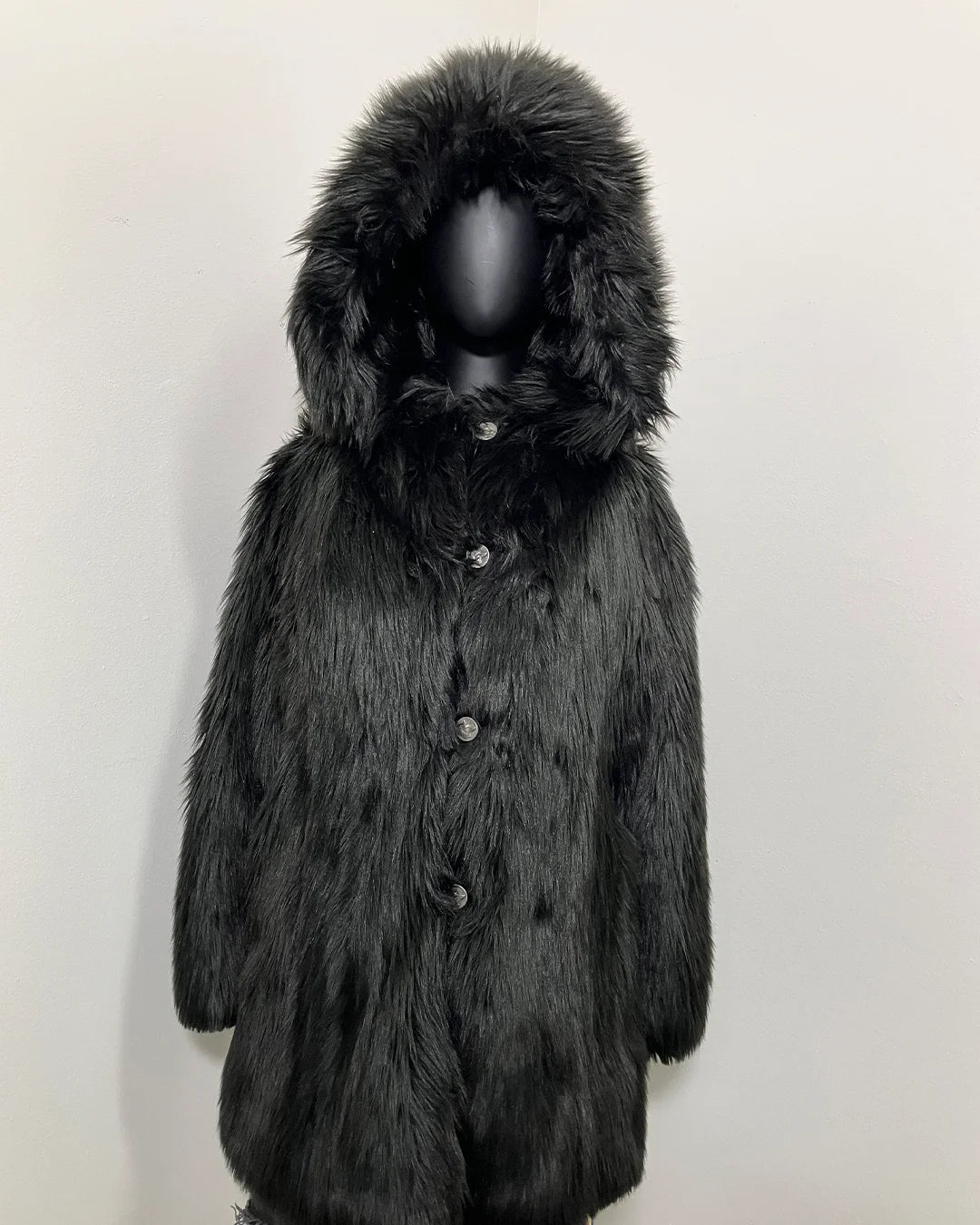 mannequin wearing the Hooded Black Wolf Fake Fur Coat with the hood up and the first row of buttons closed showing the peacoat button closure and wolf face buttons on this XS online sample sale style.