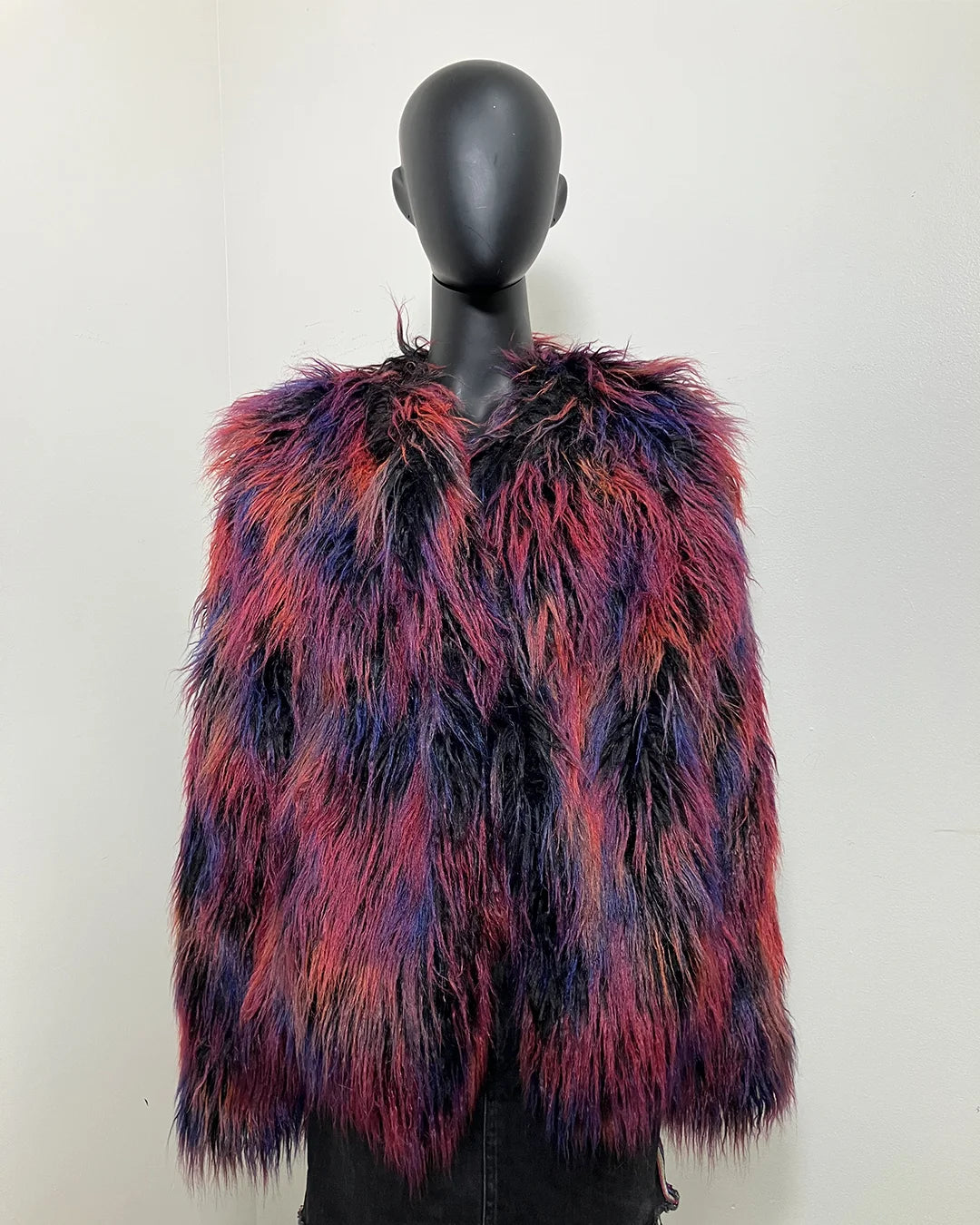 Multicolored fake fur bomber jacket on a mannequin against a white background