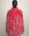 Mannequin wearing a neon pink faux fur coat with black leopard print pattern on a white background