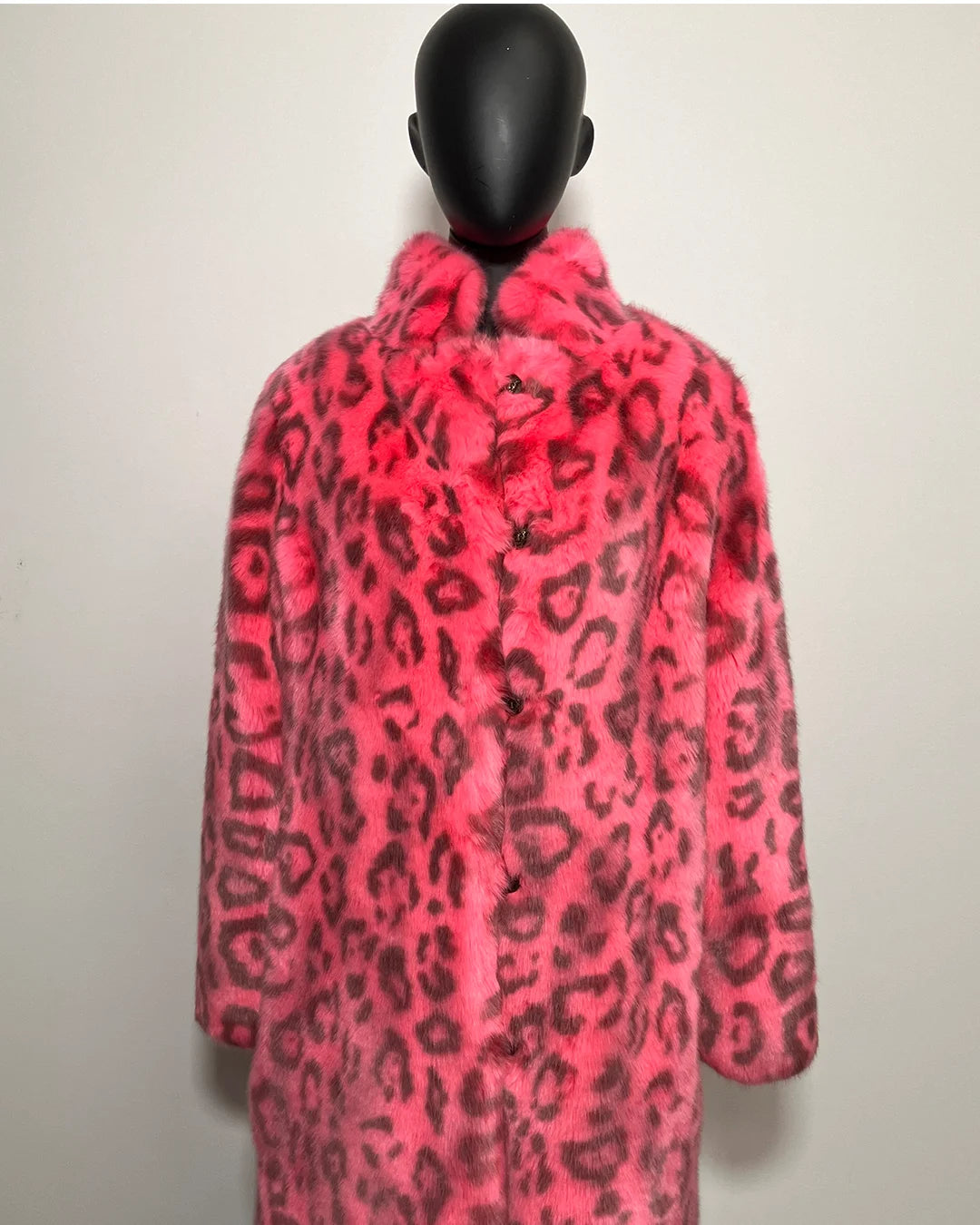Mannequin wearing a neon pink faux fur coat with black leopard print pattern on a white background