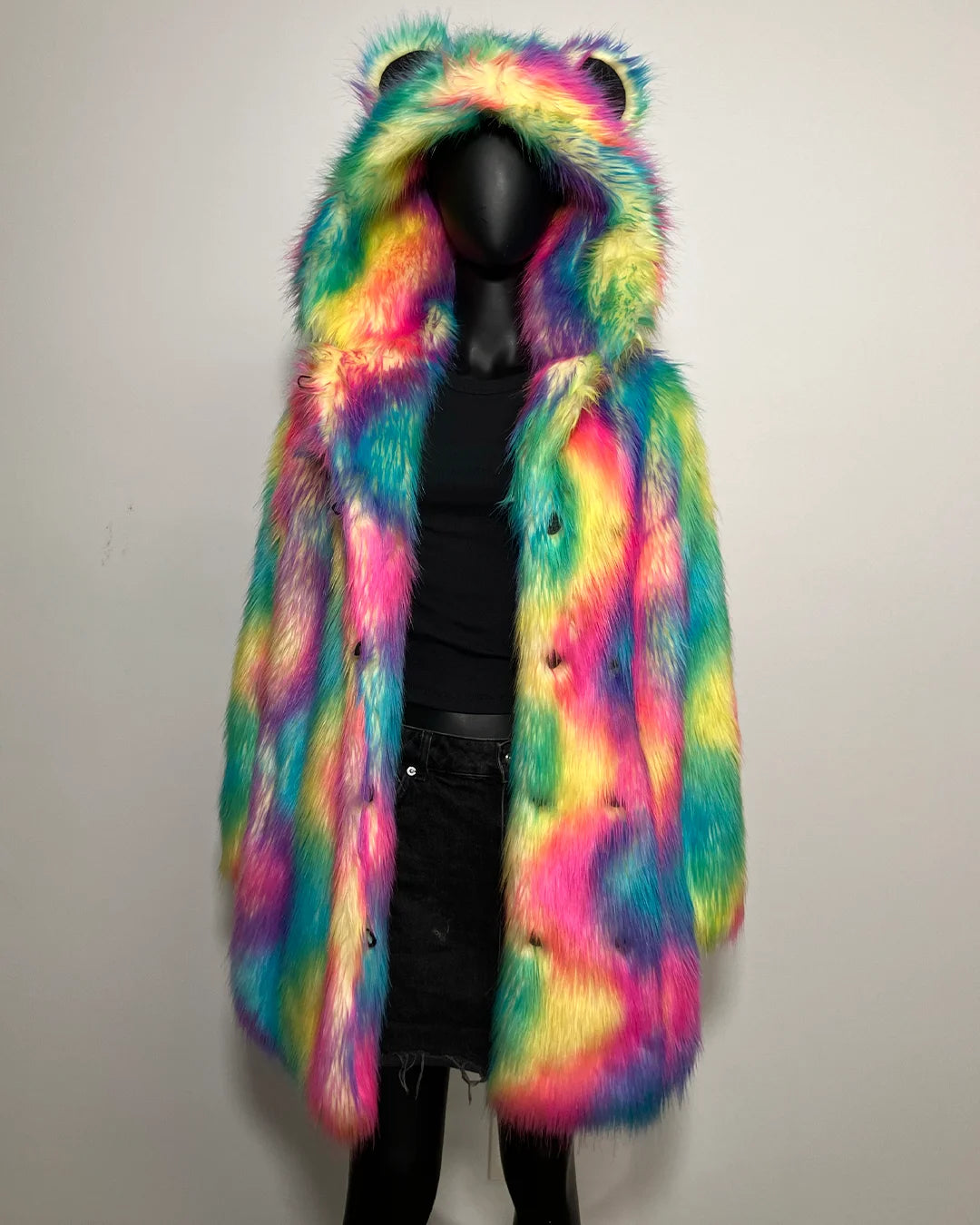 Multicolored fur coat with bear ears on a mannequin against a plain background