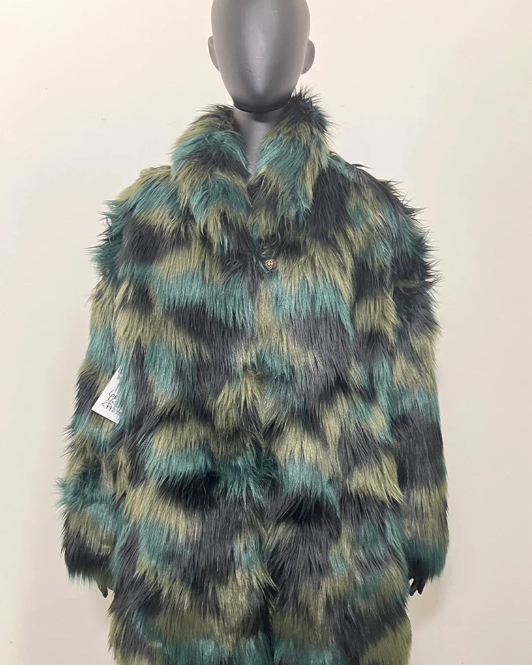 Faux Fur coat with green and black pattern on a mannequin against a white background