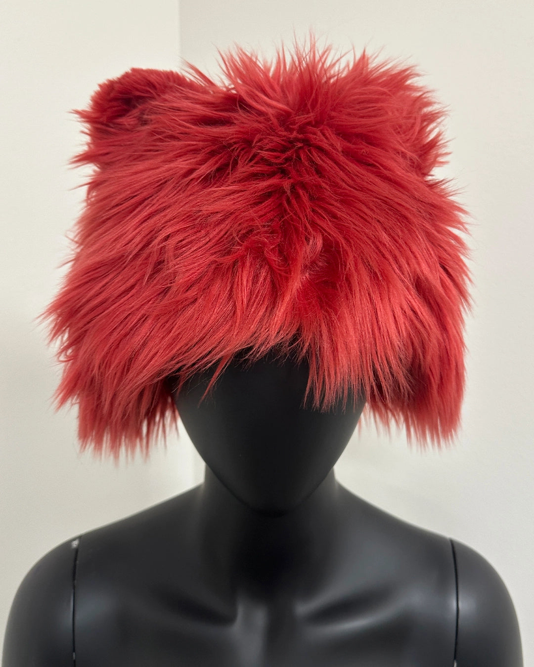 Red fluffy hat on a black mannequin 