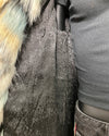 Close-up of a textured  snakeskin lining fabric surface with faux fur trim and a person wearing a gray sweater.