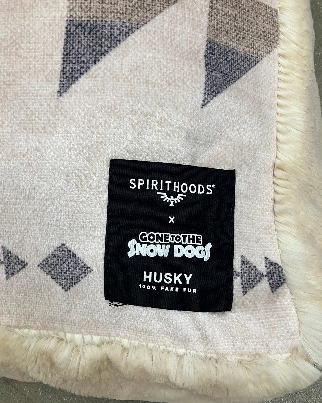 Label on a patterned fabric with 'Spirithoods' branding