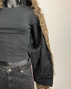 Mannequin wearing a black jacket with fur trim on a plain background
