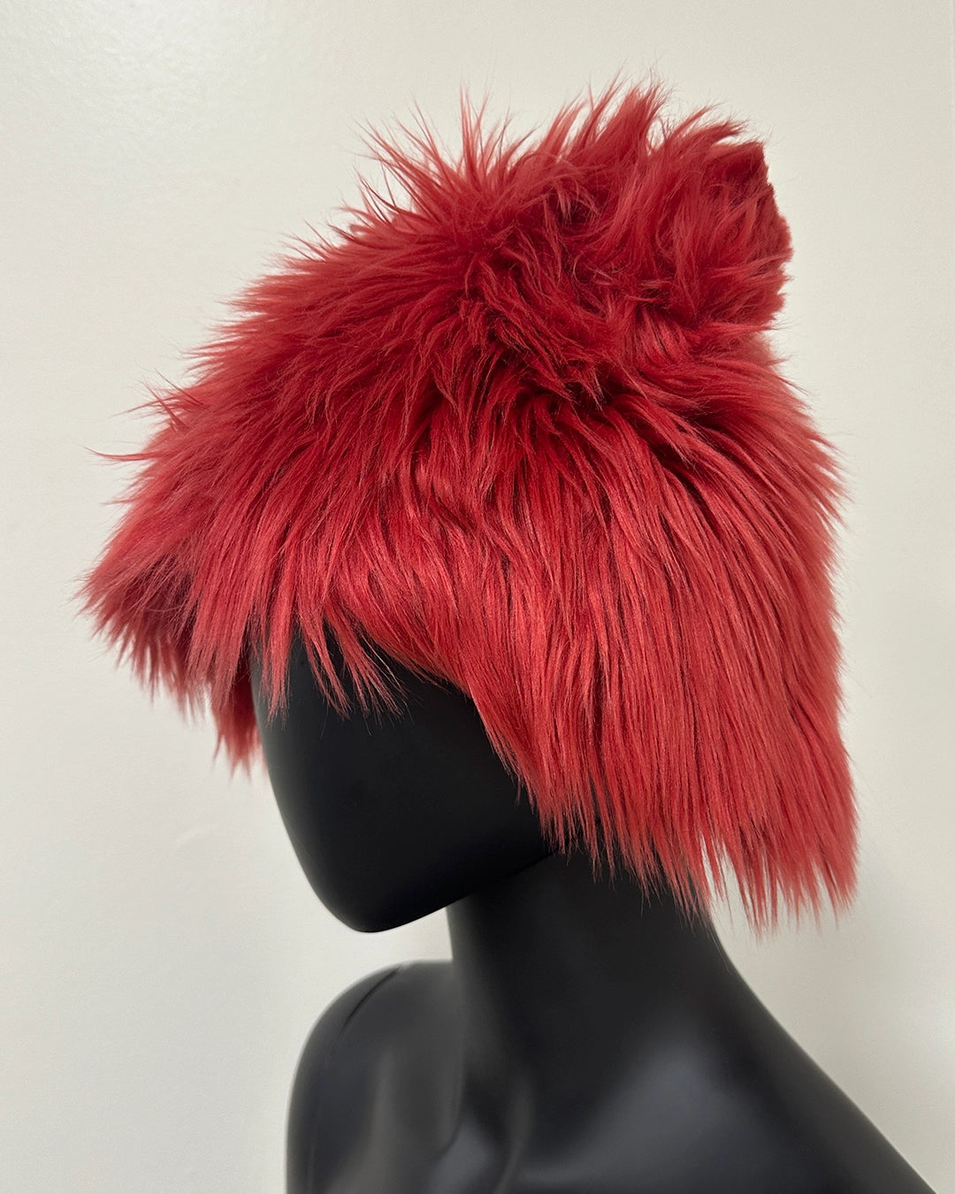 Red fluffy hat on a black mannequin 