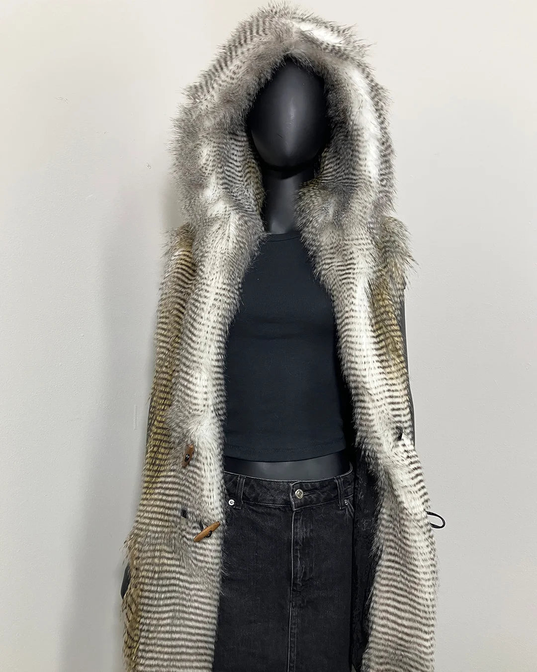 Mannequin wearing a faux fur vest with a hood on a plain background. SpiritHoods Online Sample Sale Style: Hooded Faux Fur Vest in Alaskan Hawk - Size Medium.