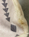 Close-up of a textured surface with geometric pattern and frayed edge.