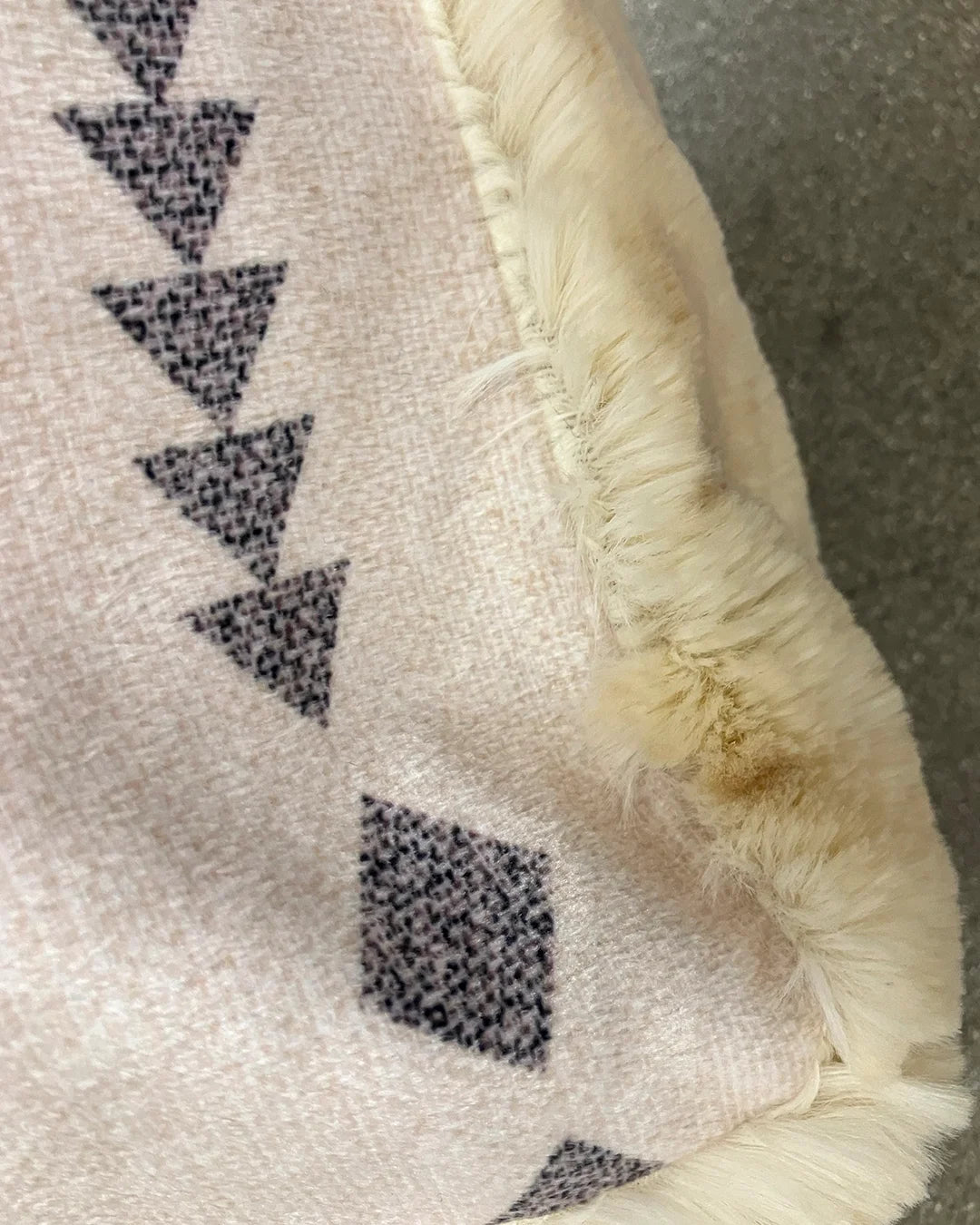 Close-up of a textured surface with geometric pattern and frayed edge.